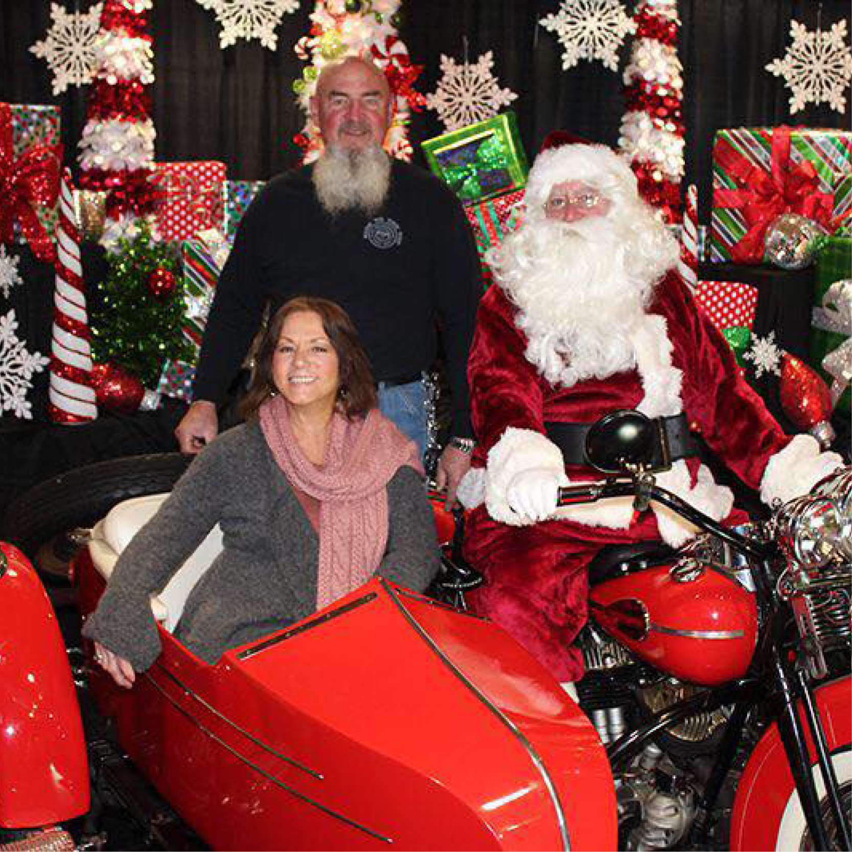 santa on a red motorcycle with a woman in the sidecar