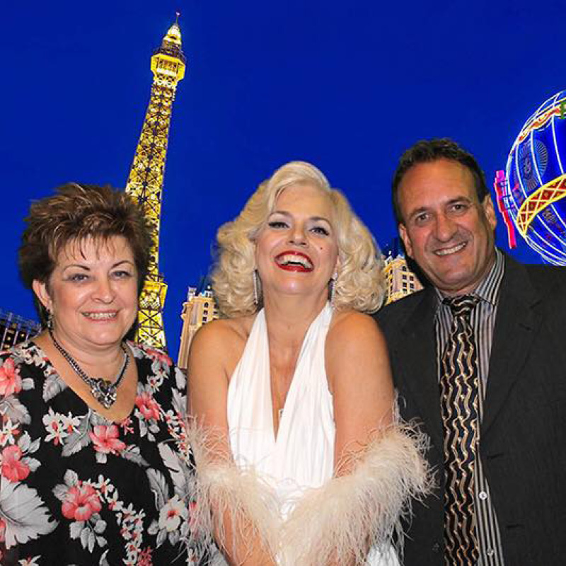 people in a photobooth with a vegas backdrop