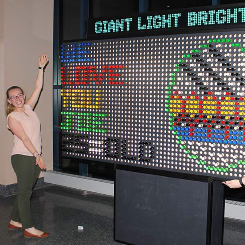 woman with giant light bright board