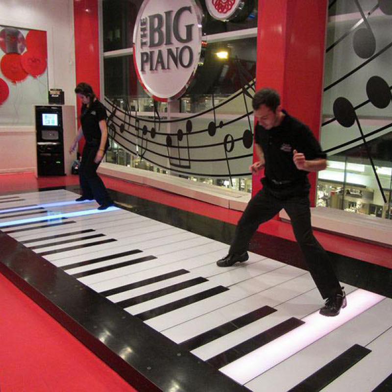 people playing on a big piano