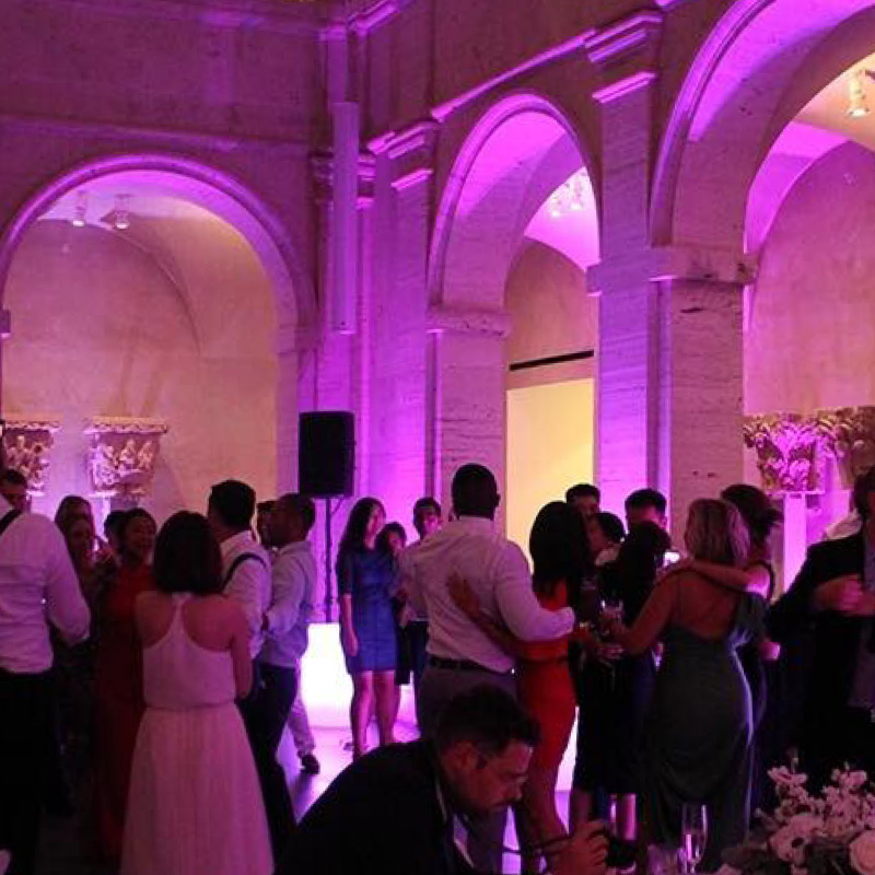 people dancing at wedding with purple uplighting