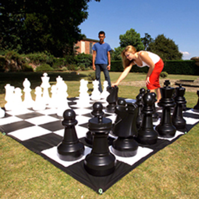 man and woman playing giant chess