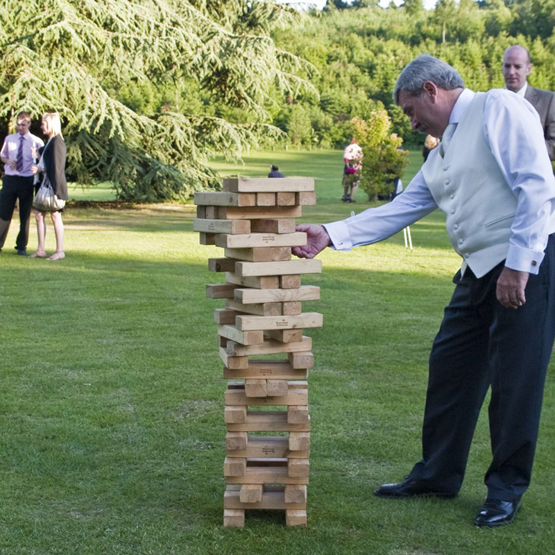 man playing giant jenga game outside