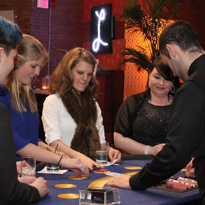 people playing card game at casino table