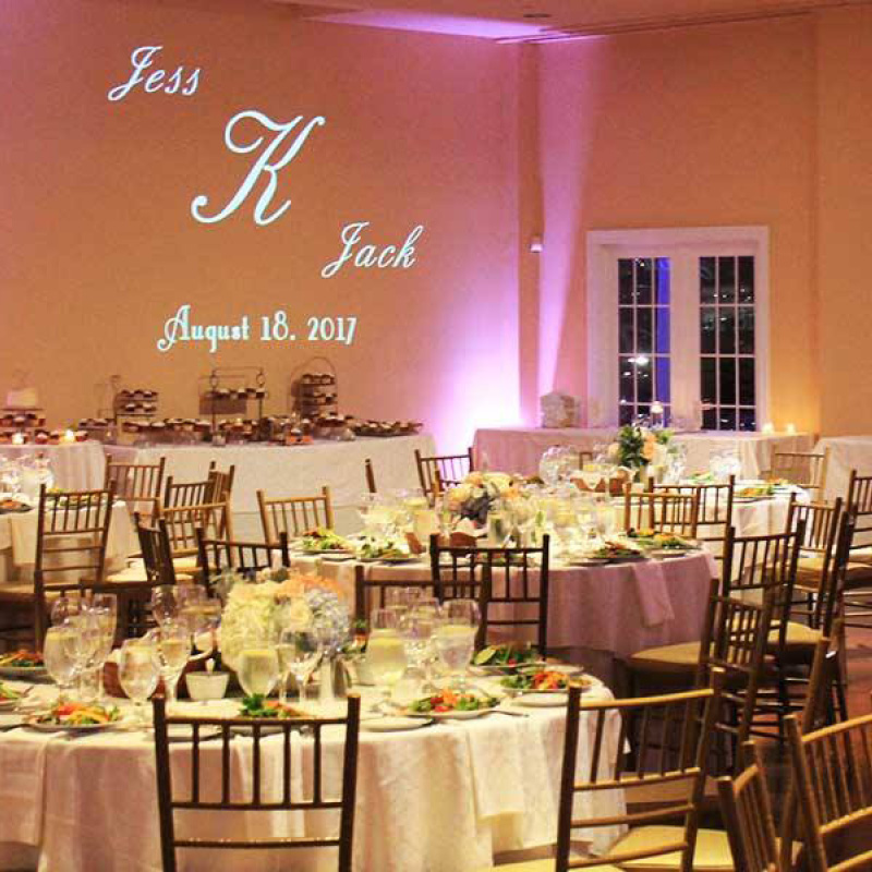 wedding reception set up with couples names on the wall in lights